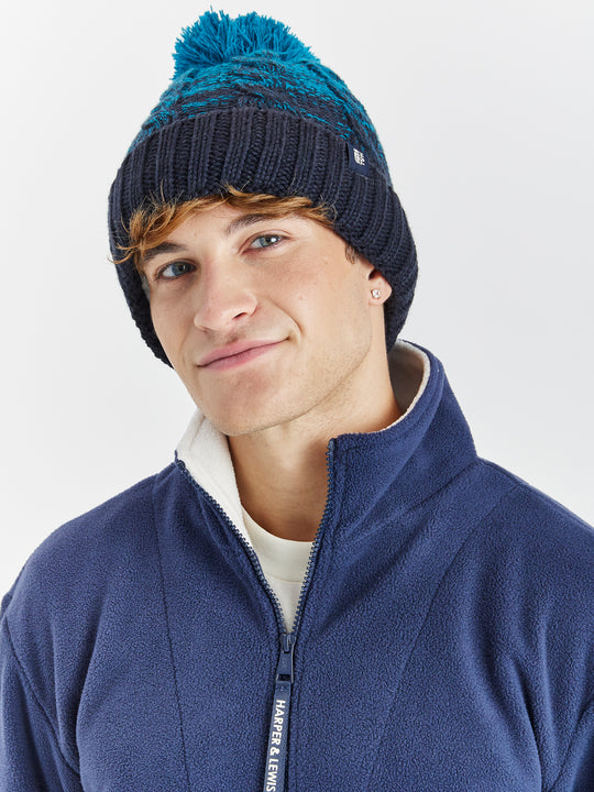 This heavyweight multi-yarn cable knit beanie is designed for both warmth and style, featuring an ombre effect.