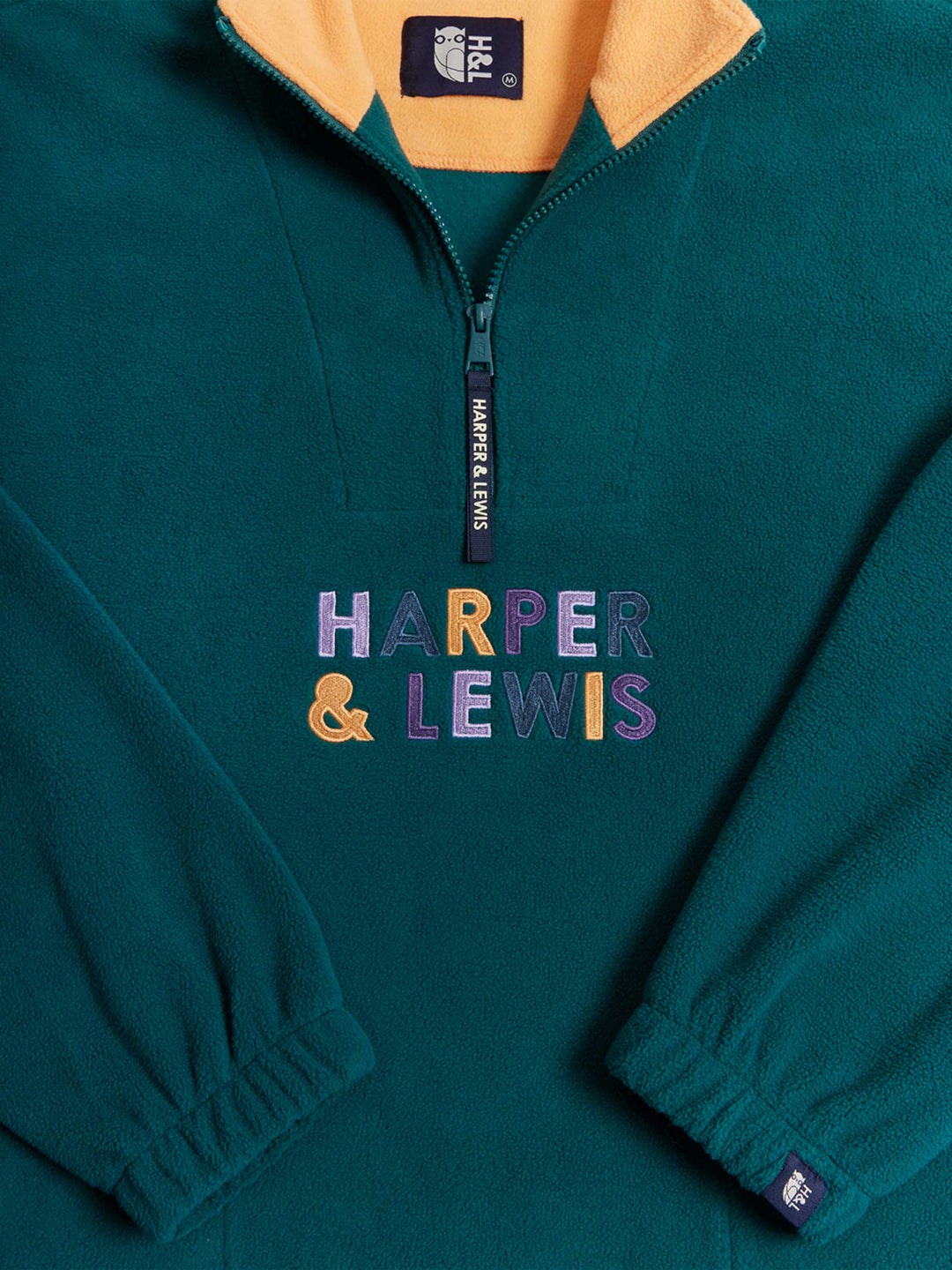 Colours to match the season in the embroidery, featuring Lavender, Deep Purple, Apricot and Petrol, to make up a colourful spellout, on this Quarter Zip Fleece.
