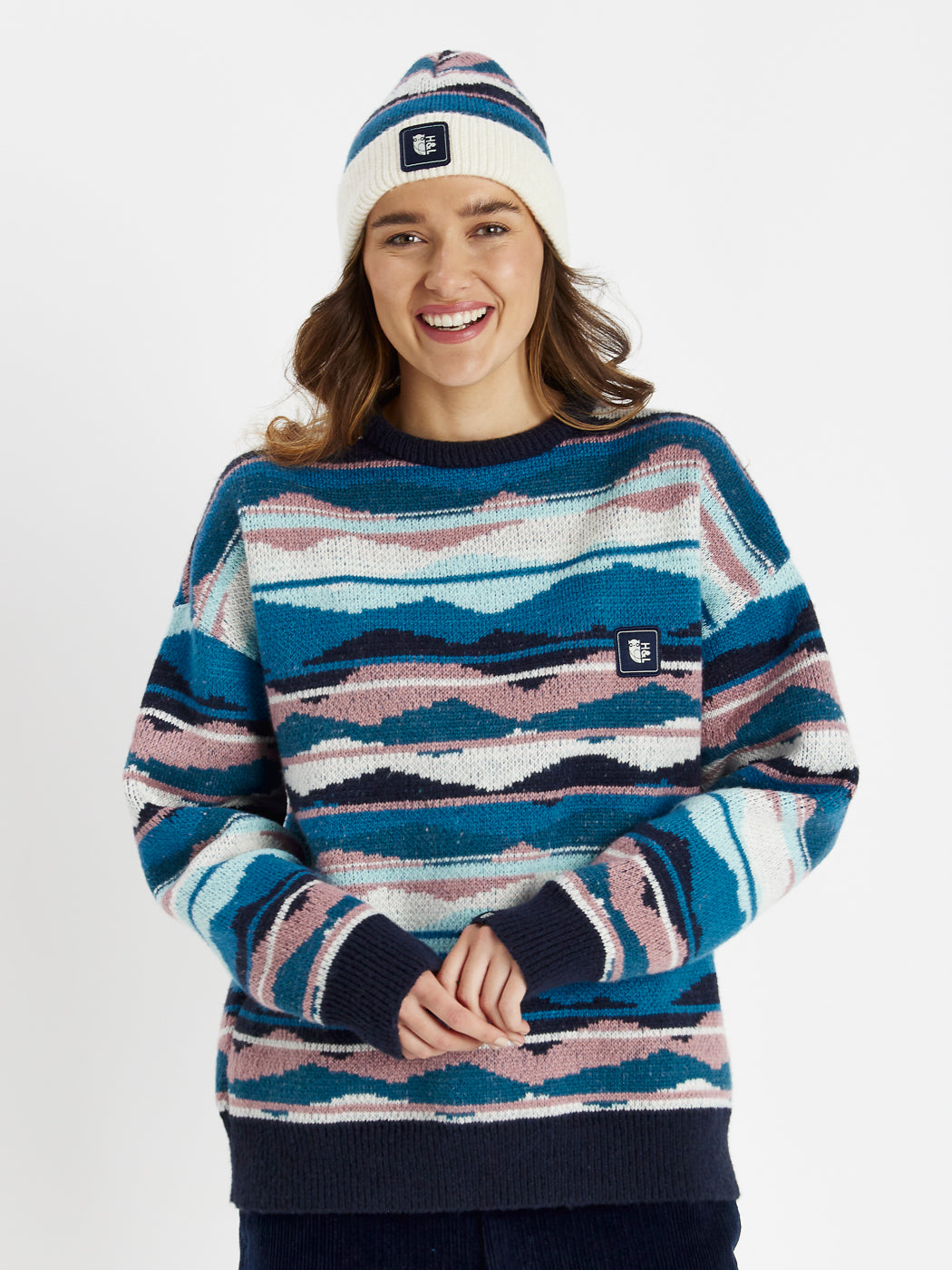 This jumper features a vibrant pattern in shades of Teal Green, Steel Blue, Dusty Pink, and Cream.