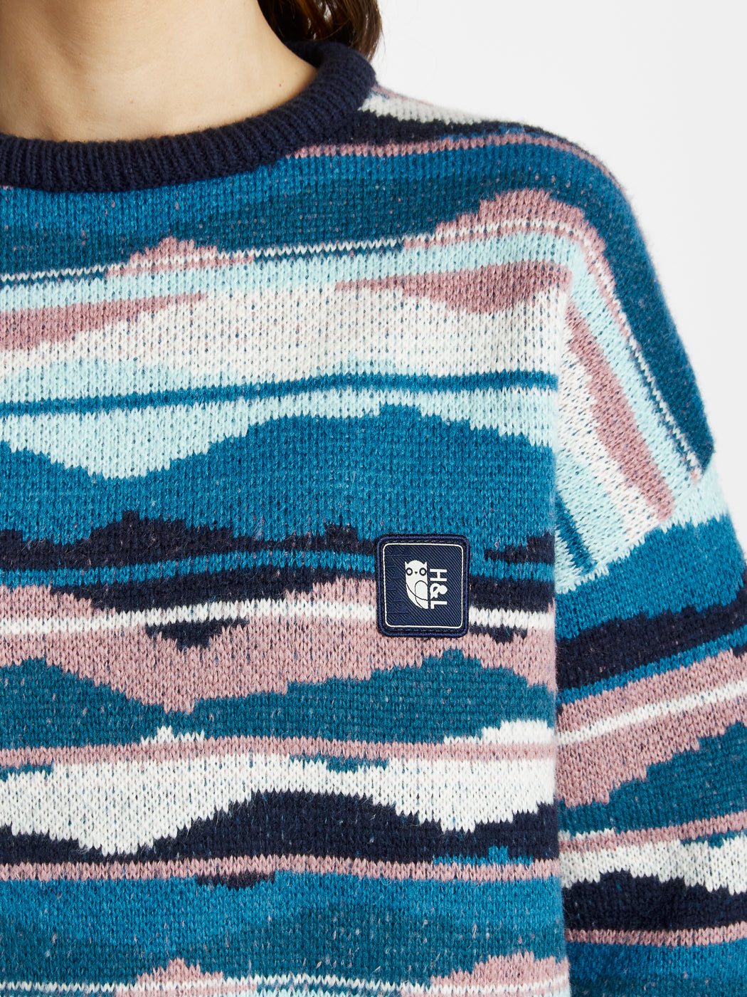 A woven branded badge at the chest and sleeve enhances its design appeal.