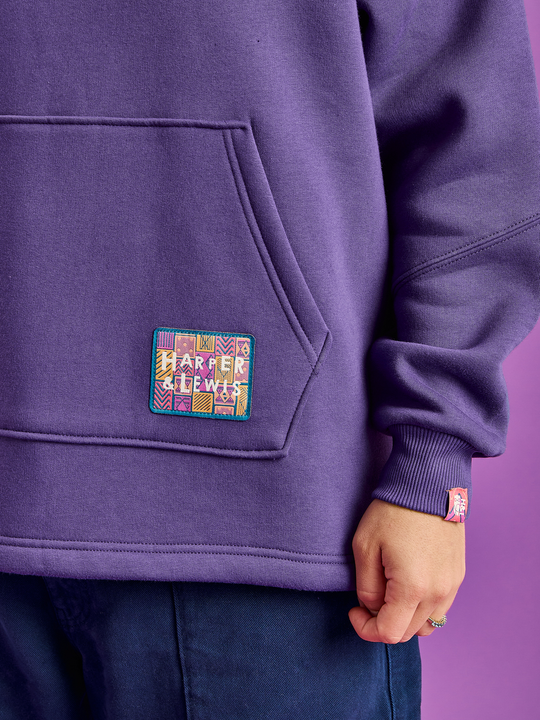 Detail shot of the branded aztec woven badge on the front pocket and the tab on the cuff.