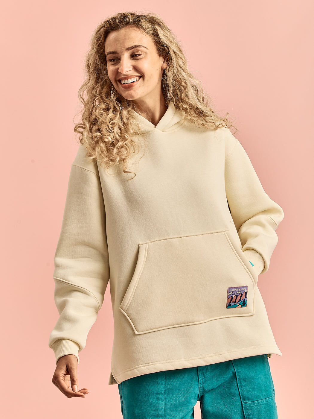 Model wearing the Willow Hoodie in butter-yellow showing the kangaroo pocket