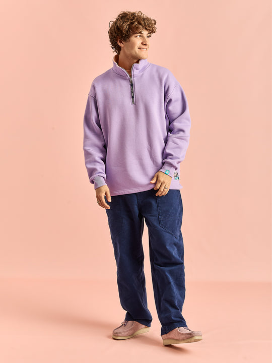 Male Model wears the oversized sweater in lavender which is made from a brushed back fleece material