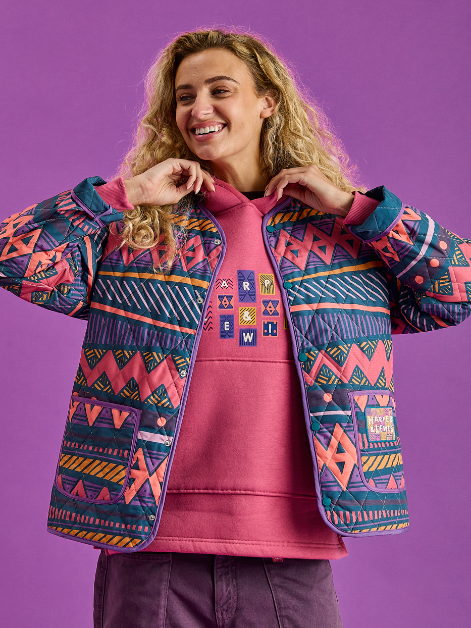 Female model wearing the warm quilted jacket in the aztec wave pattern.