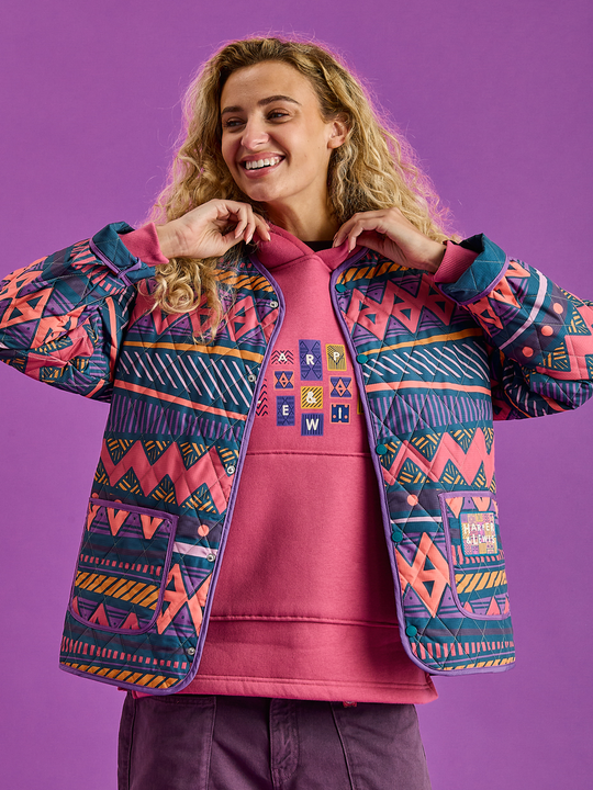 Female model wearing the warm quilted jacket in the aztec wave pattern.