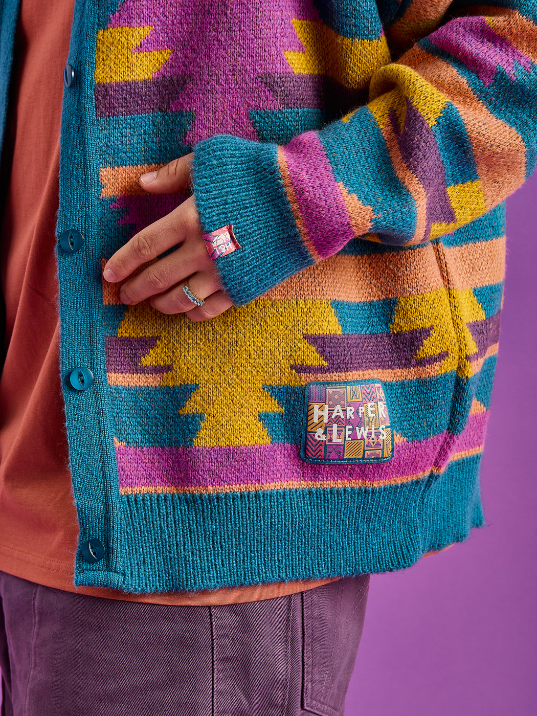 Detail shot of the branded woven retro badge on the hem and the branded tab on the cuff.