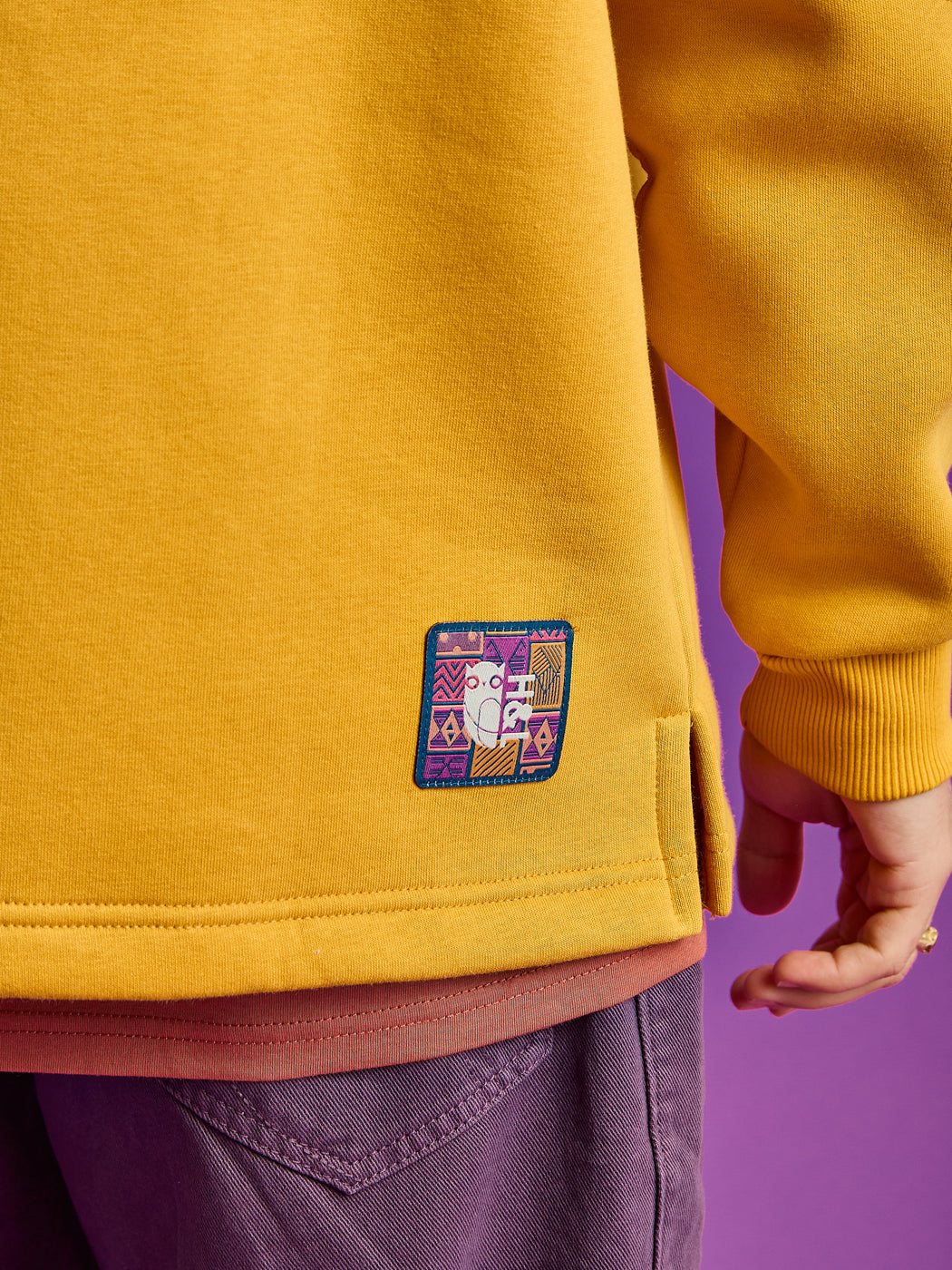 Detail shot of the branded aztec pattern badge on the back of the hoodie.