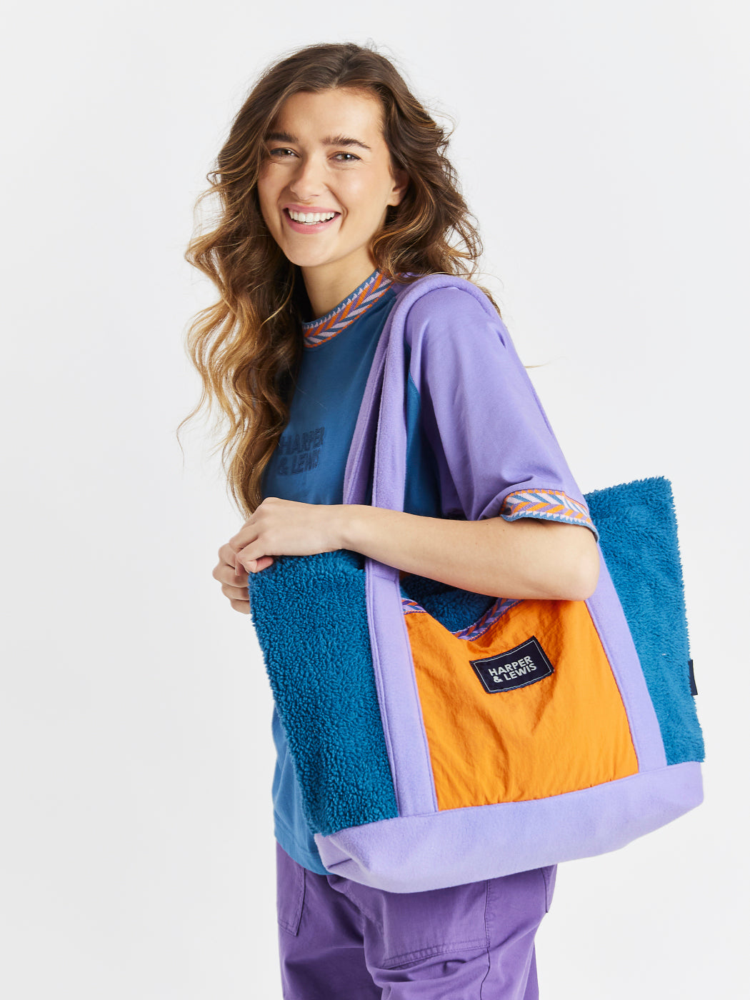 Add a touch of cosy style to your everyday look with the Sherpa Fleece Bag, designed in a vibrant mix of Petrol, Lavender, and Apricot.