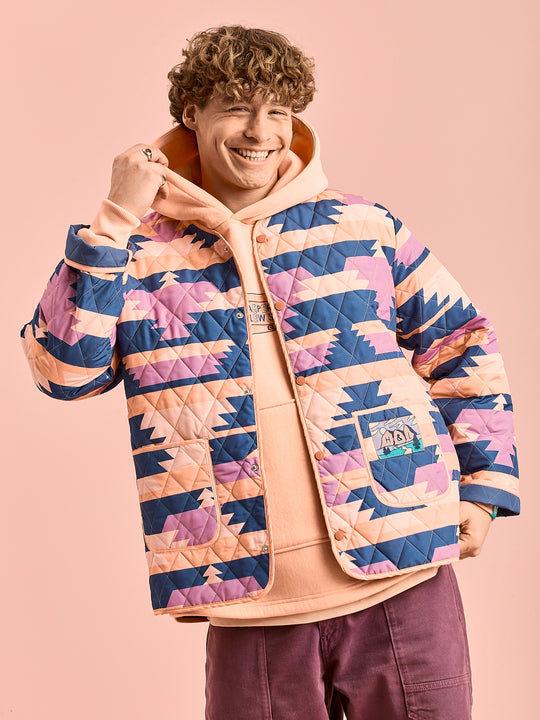 Male Model wears the unisex jacket which is perfect for layering, with a hoodie underneath