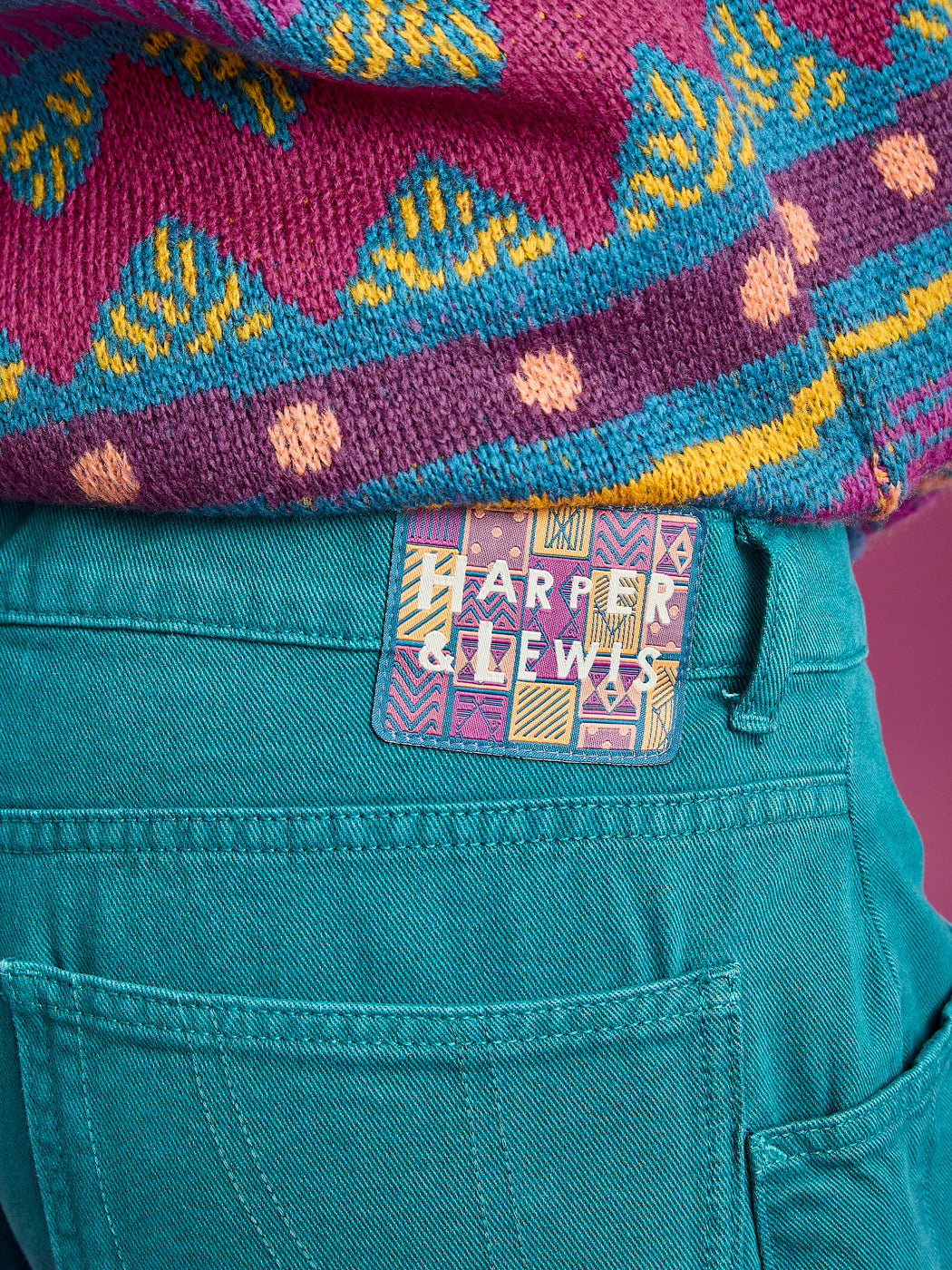 Detail shot of the teal relaxed fit trousers, the features a branded tap on the waistband