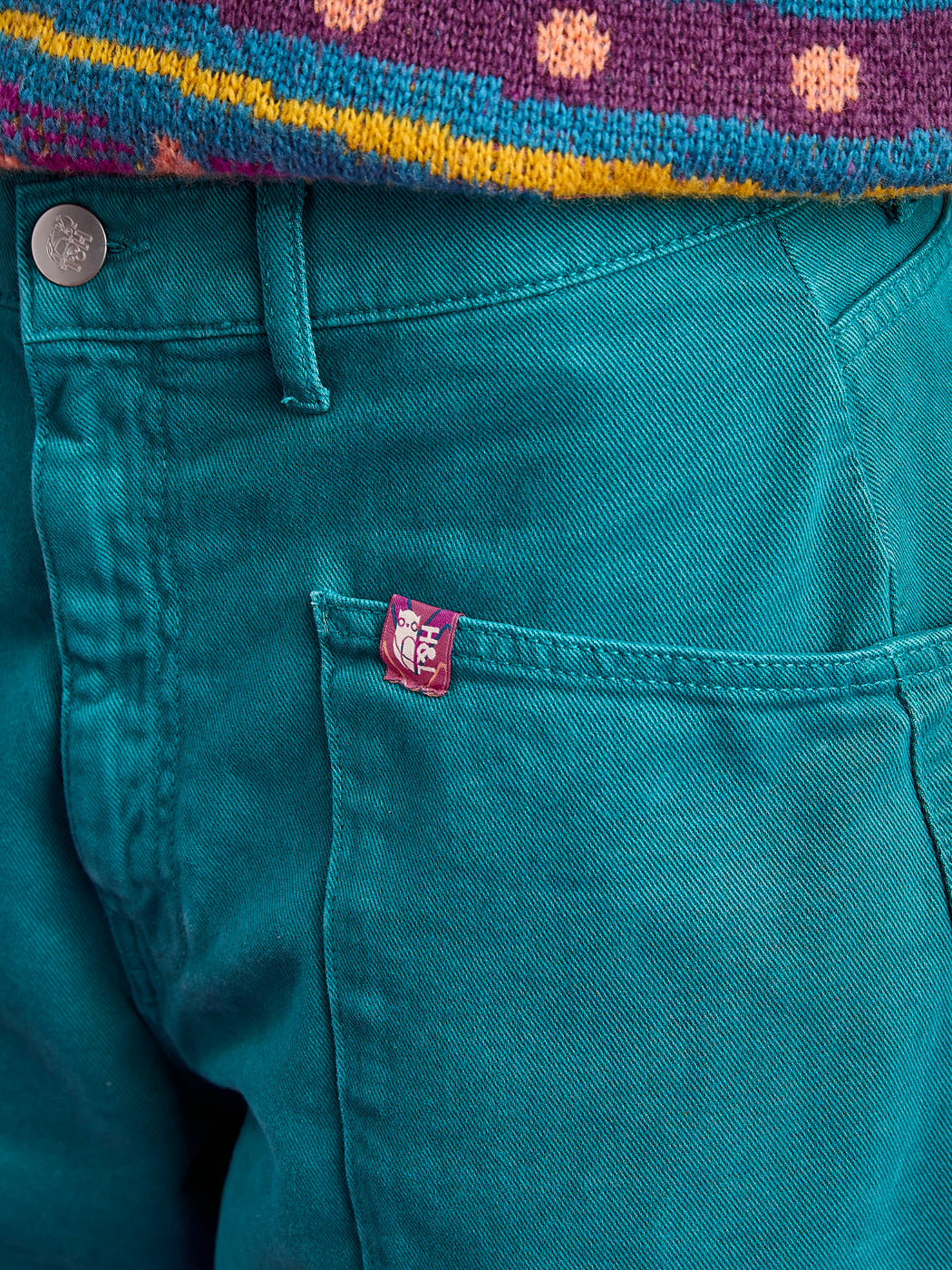 Detail shot of the belt loops and the branded tab on the front pocket of the twill bottoms