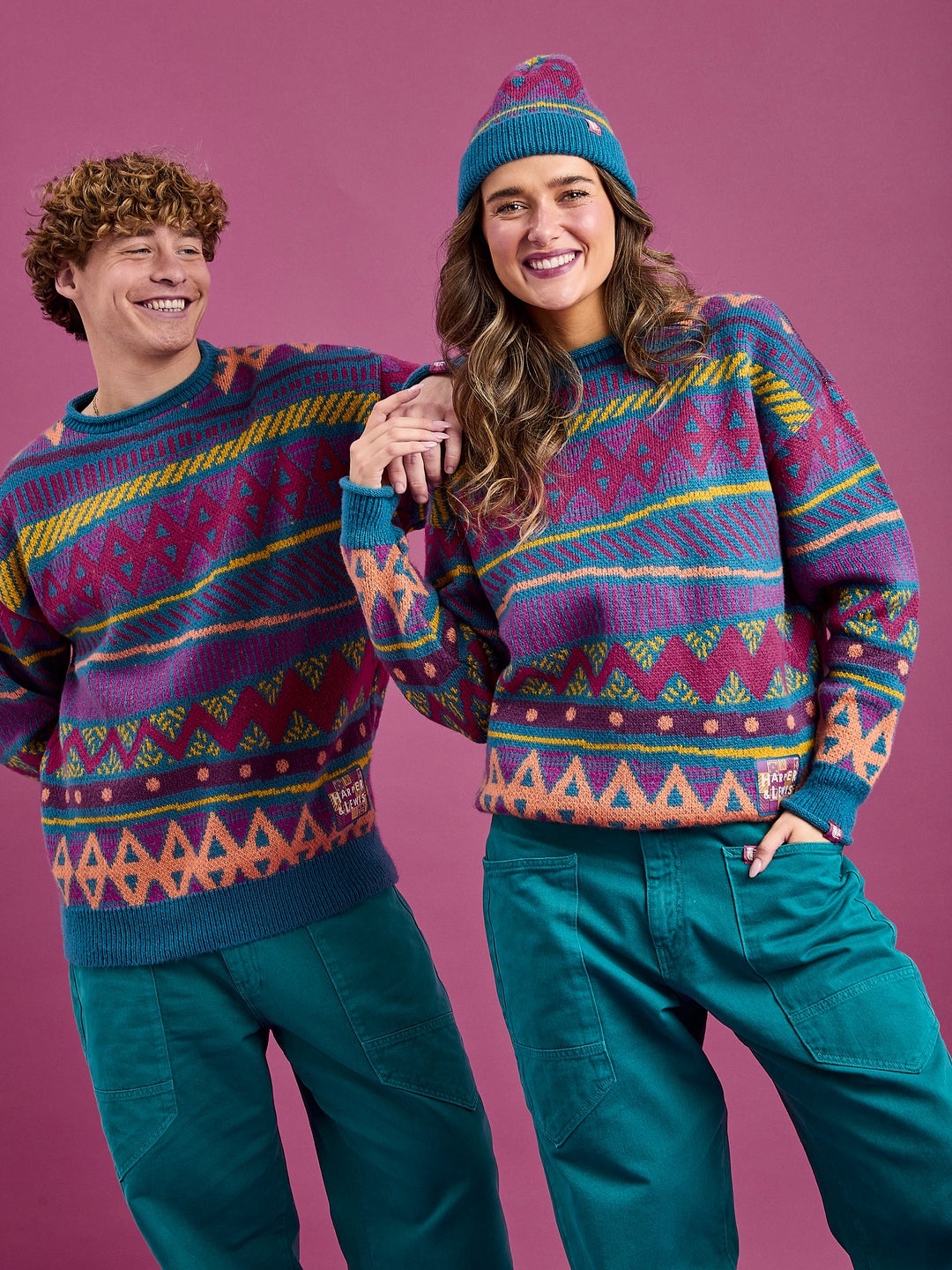 Both models wearing the unisex jumper crafted from 75% acrylic and 25% nylon, providing both warmth and durability.