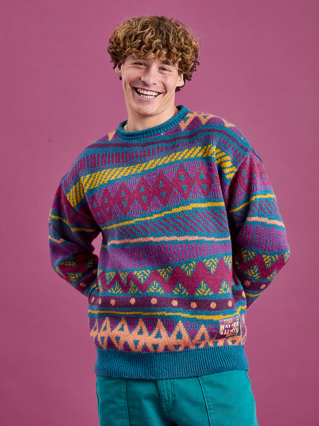 Male model wearing the oversized knitted jumper in shades of Teal, Dark Rose, Deep Mulberry, Orchid, Deep Peach & Mustard.