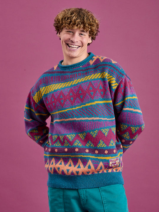 Male model wearing the oversized knitted jumper in shades of Teal, Dark Rose, Deep Mulberry, Orchid, Deep Peach & Mustard.