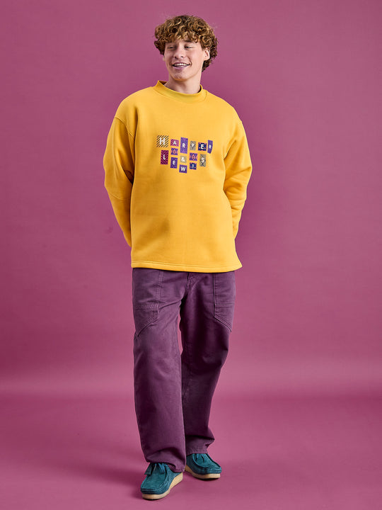 Male Model wears the Mustard sweatshirt which has a released hem for a more relax fit.