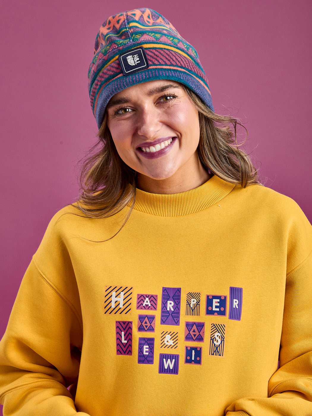 Close up shot of the female model wearing the Winnie sweatshirt, which features a bold front branded graphic.
