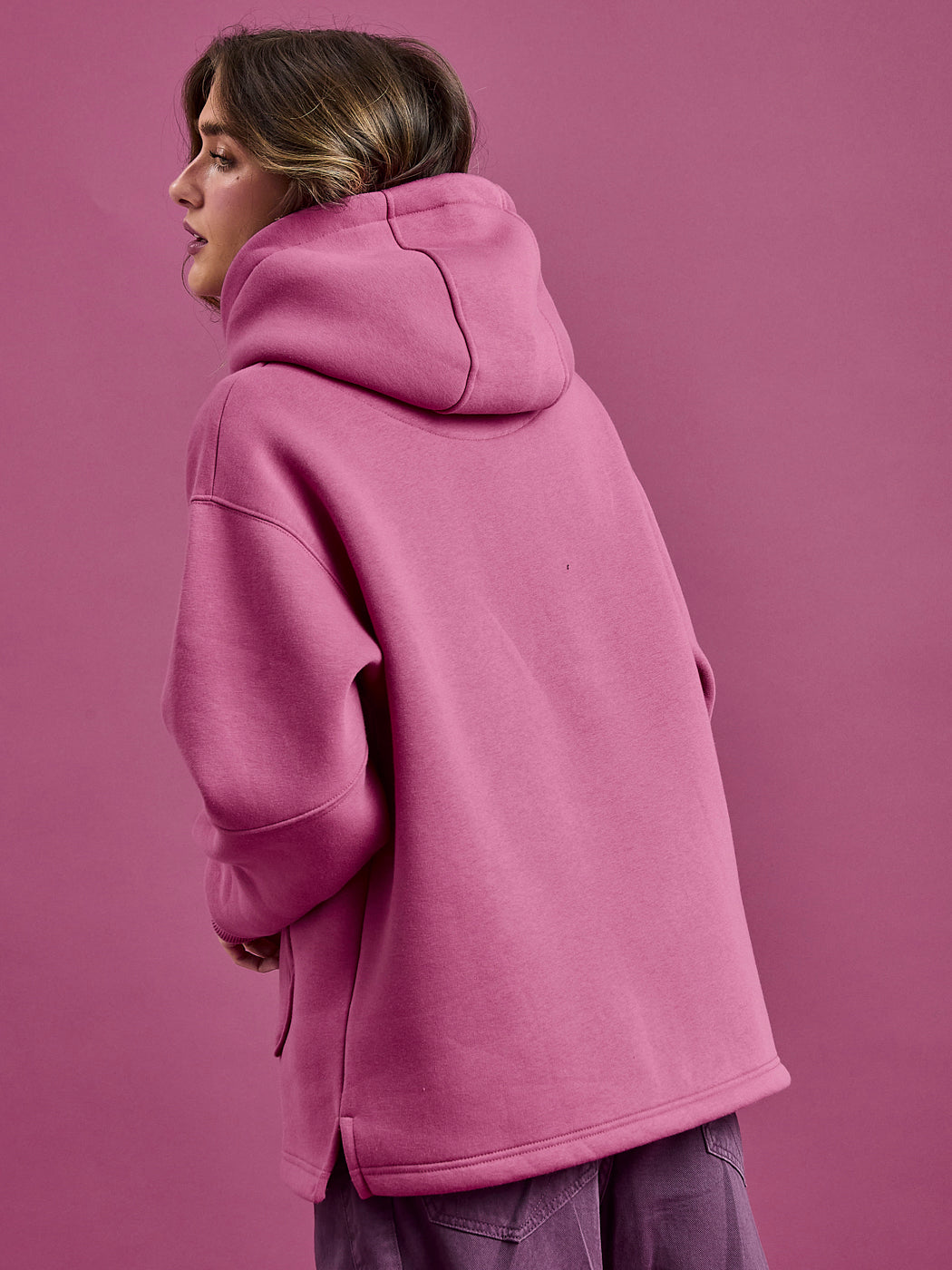 Back shot of the female wearing the Garnet hoodie, featuring a oversized hood.