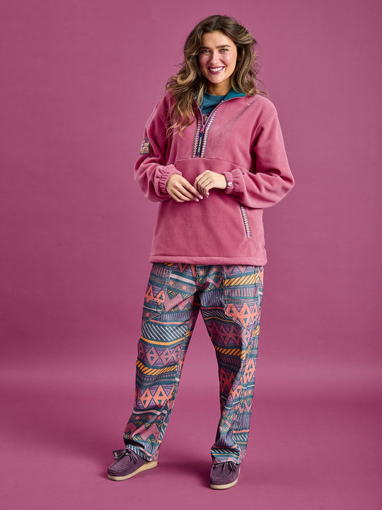 Female Model wearing the Dark Rose Fleece jacket, showing the details of the fleece, styled with the matching patterned trousers.
