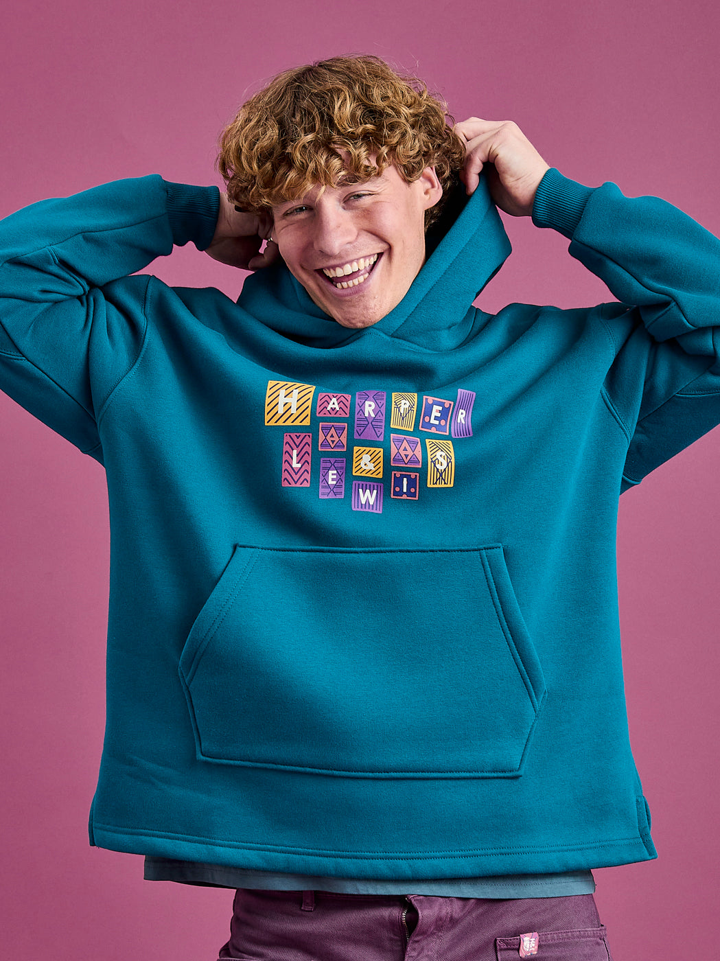 Male Model wearing the teal unisex hoodie made from a robust blend of 65% Cotton and 35% Polyester.