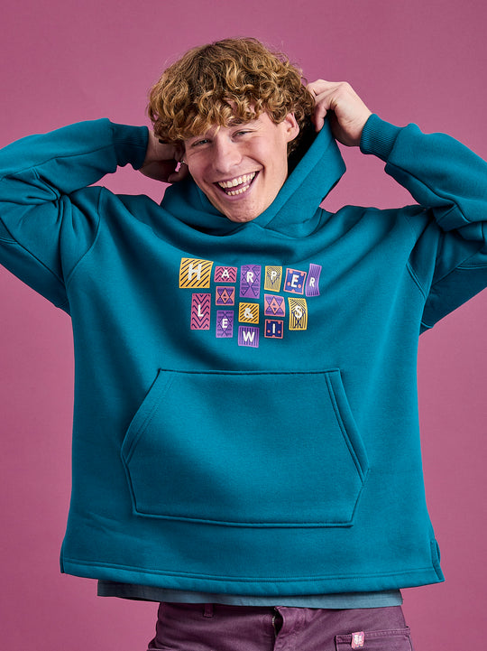Male Model wearing the teal unisex hoodie made from a robust blend of 65% Cotton and 35% Polyester.