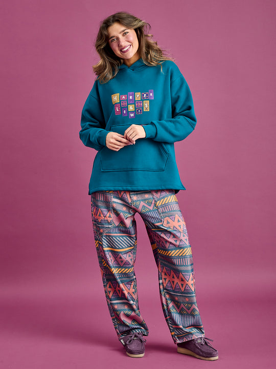 Female model wears oversized ladies hoodie with Woven branded tabs on the cuff and hem add a distinct flair.