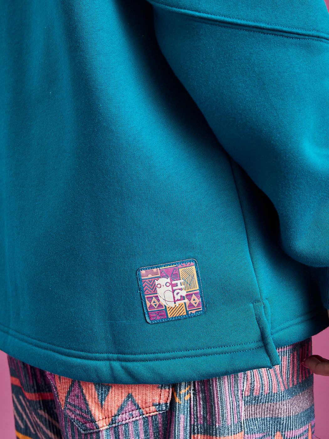 Branded badge on the back of the hem.
