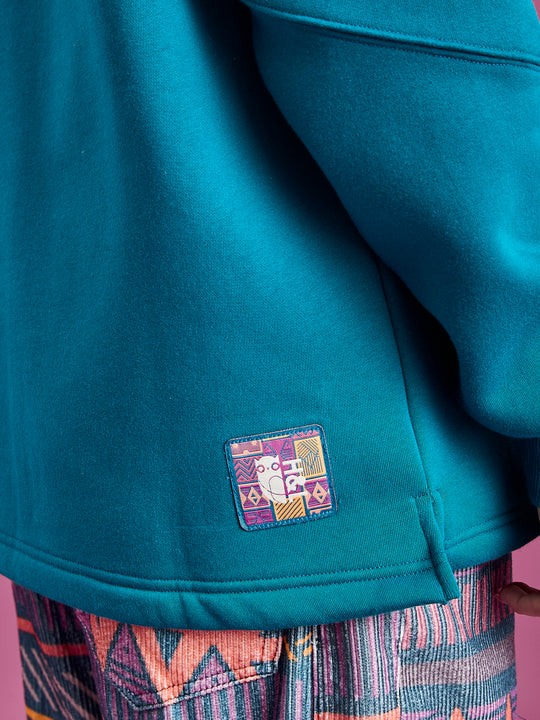 Branded badge on the back of the hem.