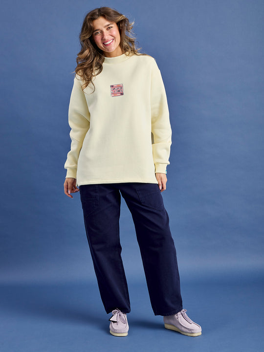 Female Model wears the Atlas sweatshirt in cream.