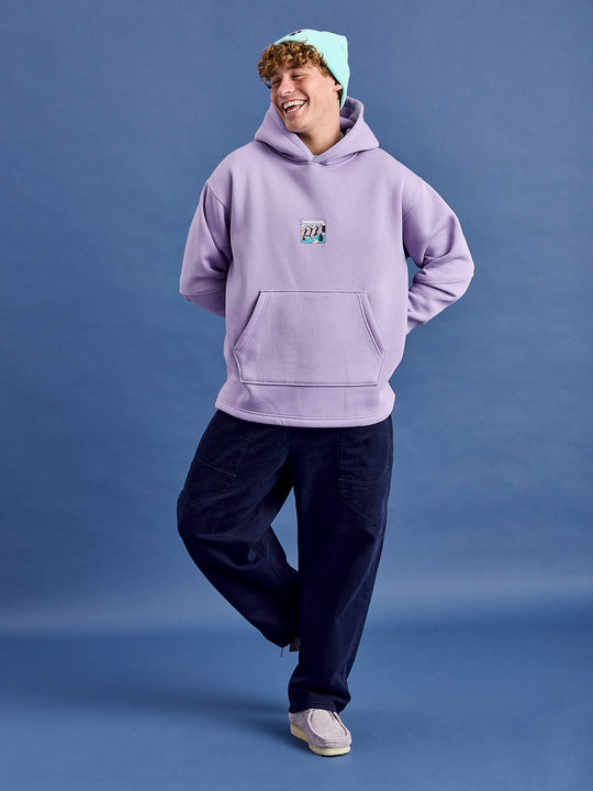 Male Model wears a oversized unisex hoodie with a released hem.