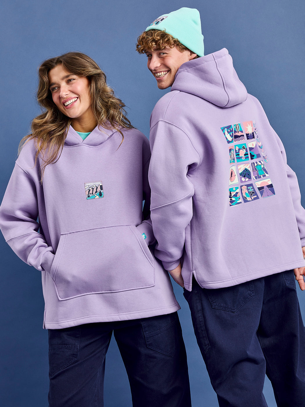 Both Models wearing the Ellerie Hoodie in lavender. Featuring a front badge and a back graphic.