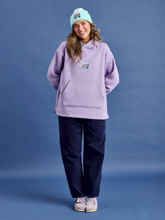 Female Model wears a lavender hooded sweater constructed from plush fleece-back jersey, this hoodie offers a warm and cosy interior, ideal for everyday comfort.