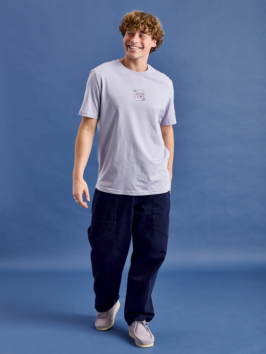 Male Model wearing the Atlas unisex t-shirt styled with navy trousers