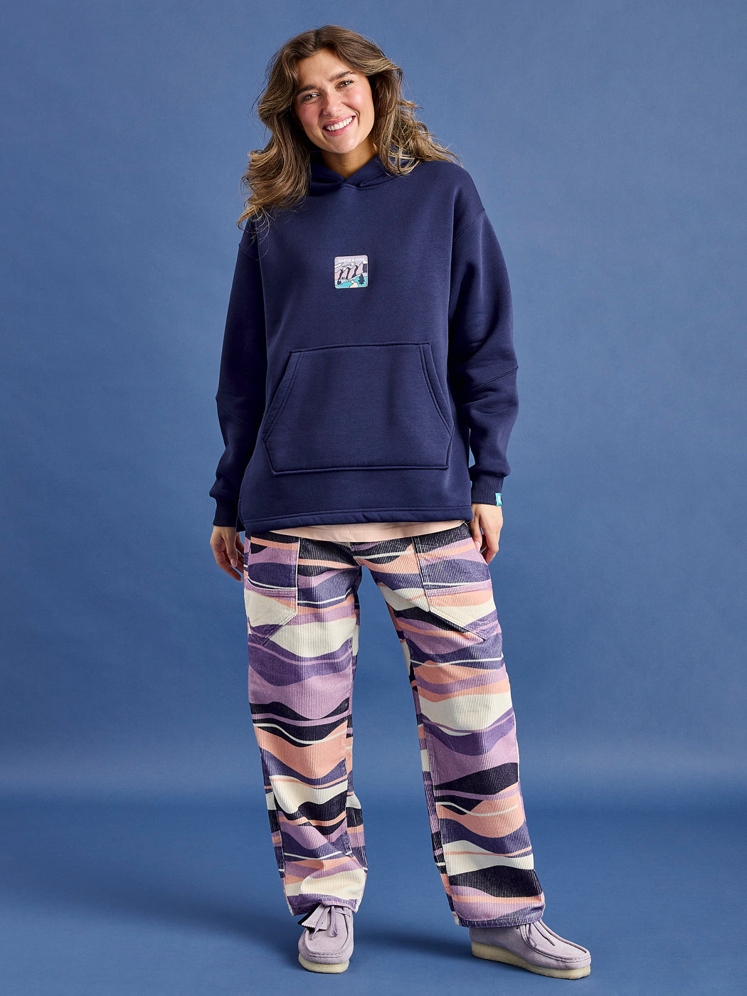 Female Model wears the Ellerie Hooded Sweatshirt in Navy styled with the Darby Trousers in Mountain Wave.