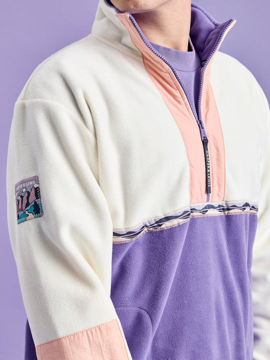 Detail shot of the branded mountain inspired badge logo and the branded navy zip puller.