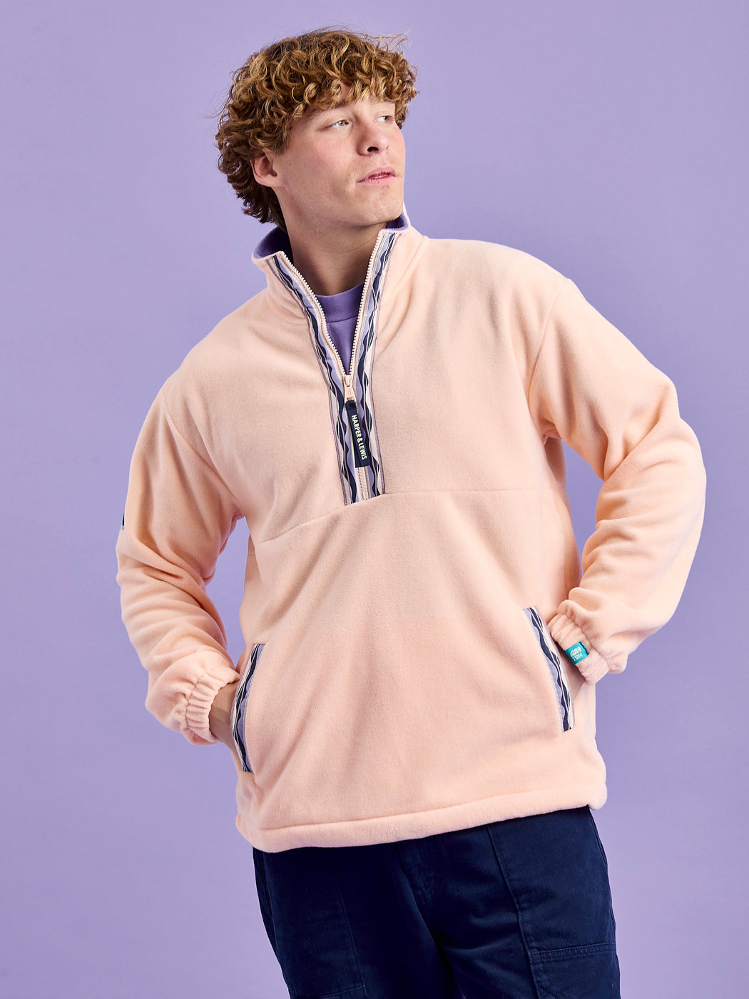 Male Model wearing the unisex fleece jacket, showing the side entry pickets with the patterned tape.