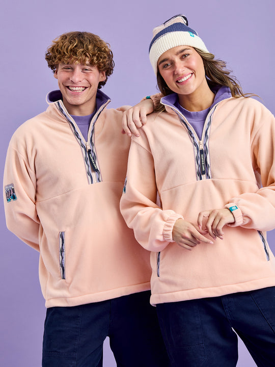 Both models wearing the Light peach unisex fleece jacket with contrasting deep lavender inside collar. 