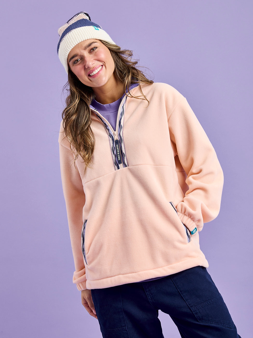 Female Model wearing the Light Peach plain fleece with Mountain Wave Pattern woven tape at placket and pockets.