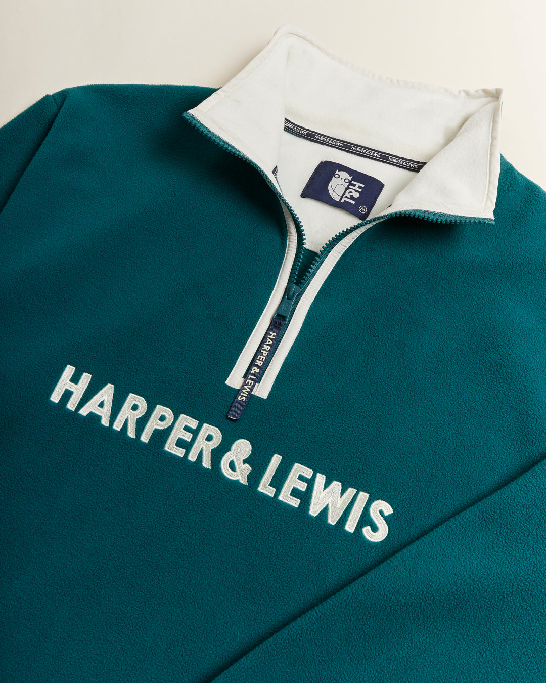 Comfort-fit Harper & Lewis Polar Fleece, with a relaxed silhouette, 1/4 zip collar, and soft fleece texture. Embroidered chest logo adds a refined touch.
