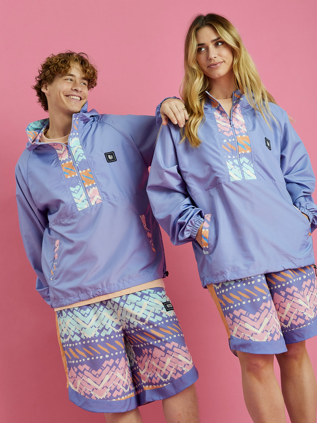 Male and female model wearing the Rene /4 Zip Hooded Jacket, this is made from a lightweight fabric in a lavender with our festival print on the accents.