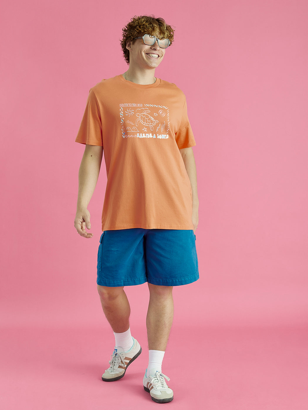 Male model wearing this Apricot tshirt casually with some patterned shorts.