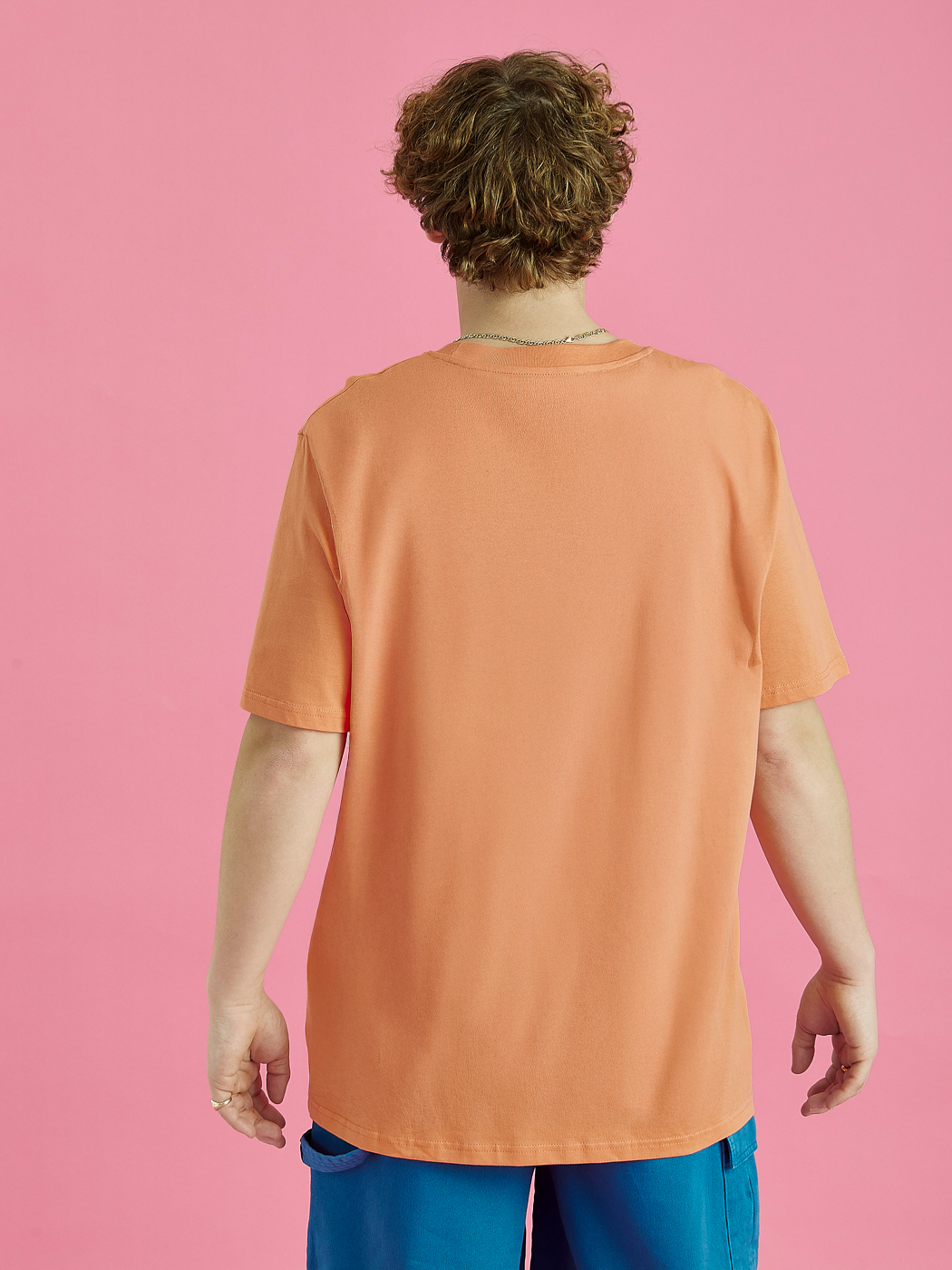 The plain back of the unisex Surya tee in Apricot.