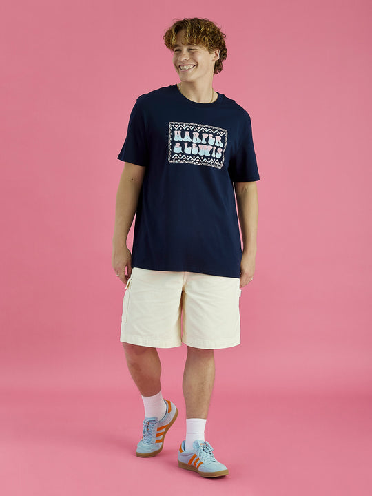Male model wearing this Navy blue tshirt casually with some cream shorts.