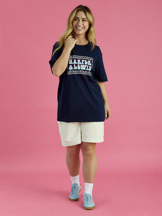 Female model wearing the Taran tee in navy blue, the tshirt has a slightly oversized fit and is made from 100% cotton.
