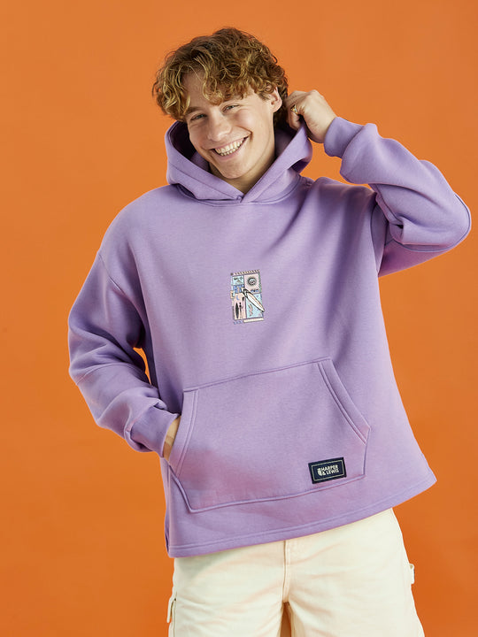 Male Model wearing the Cruz hoodie in Purple, this is adorned with a Tribal Graphic on the back and a Harper & Lewis emblem on the front, a nod to our vintage-inspired roots.