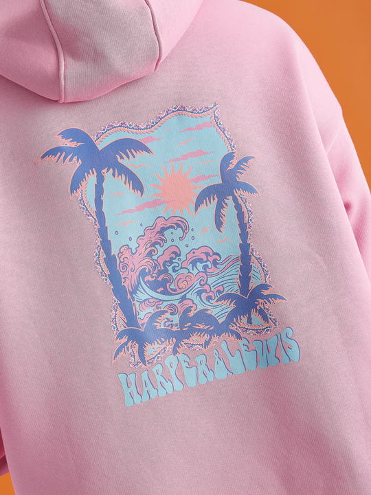 The Cruz Hoodie in Peach, this is showing the back print on the, which is tropical inspired with a wave and palm tree graphic.