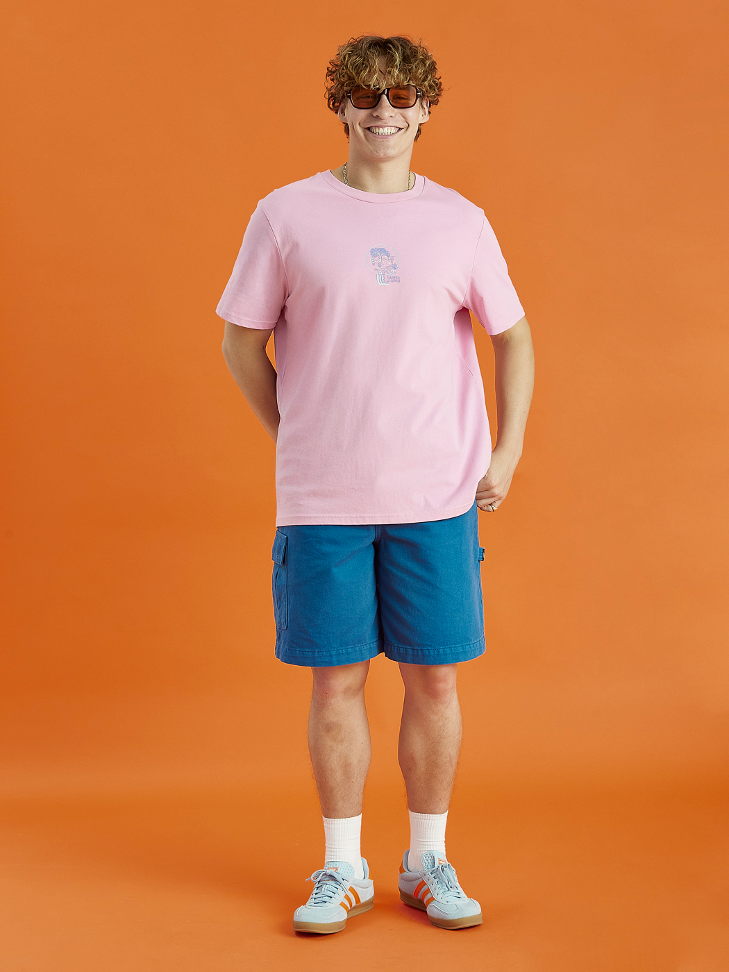 Male model showing the light pink aura tee. This has a relaxed fit and has a front and back graphic