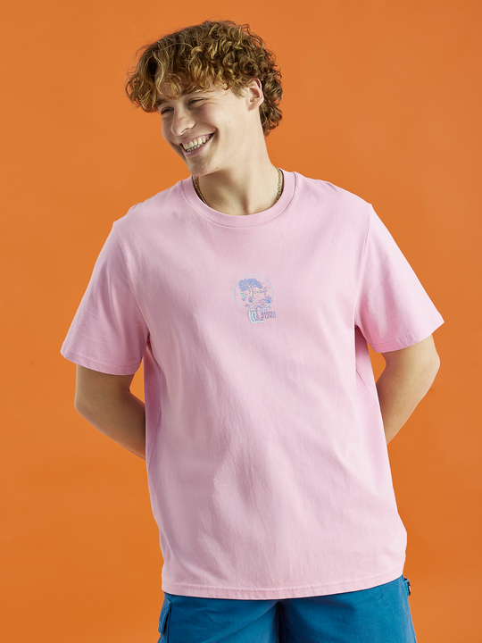 Male Model showing the pink t-shirt with front graphic, styled with our Ottis shorts in petrol.