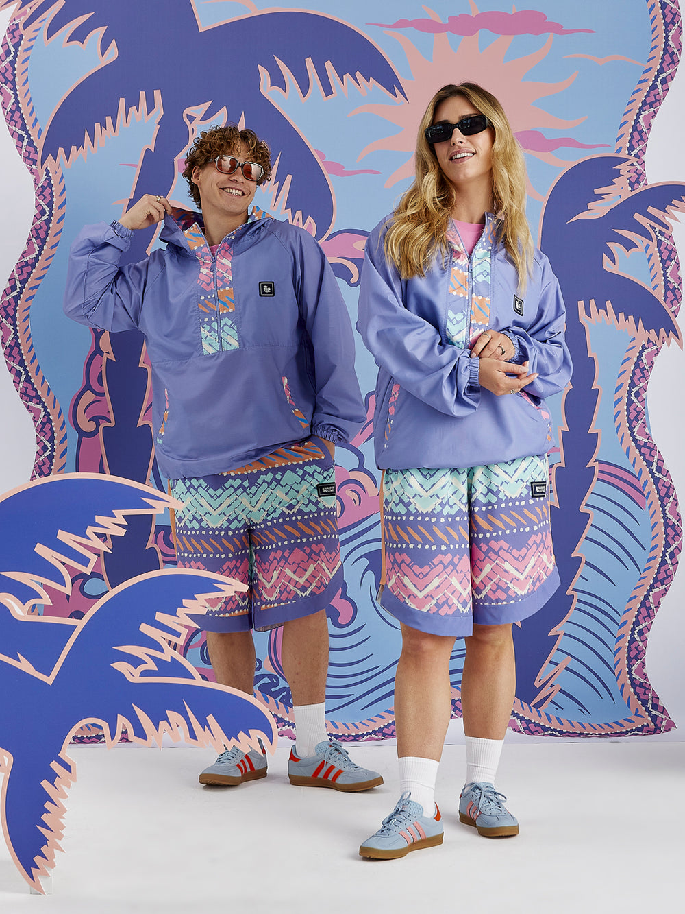 Female and male model wearing the Jett Shorts, These are a long board short which has lots of details.
