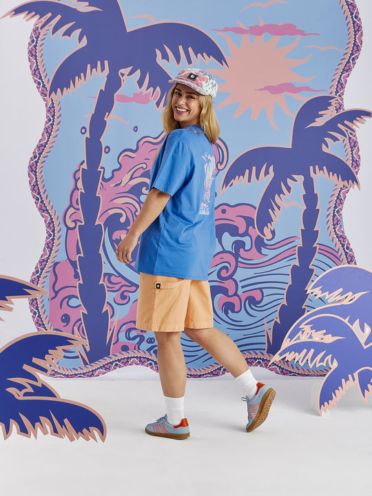 Detail shot of the tropical graphic print which features colours of Blue, light blue, peach and dusty pink.