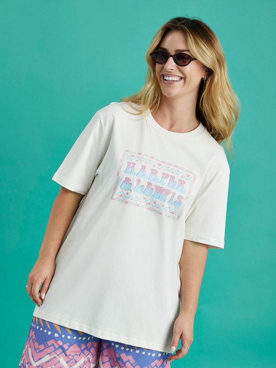 Female model wearing the Taran tshirt in a cream colour, this tee has a relaxed oversized fit.